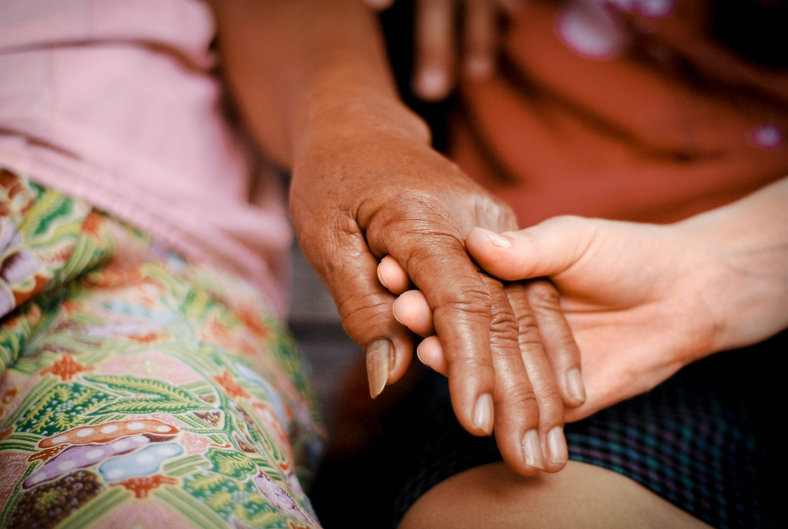 a close up of two people holding hands